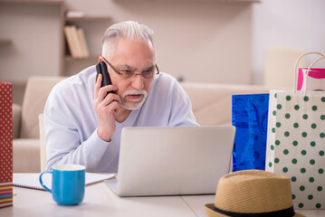 Old man with many bags in Christmas concept at home