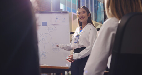 Confident young businesswoman or speaker sharing ideas with colleagues or audience during company...