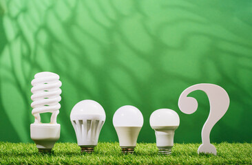 Choice question mark. Assorted led bulbs in green background. Environment earth day. Safe disposal, ecology concept. Renewable energy efficient technologies. Climate change and ethical consumerism
