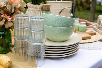 pile de bols verts et d'assiettes blanche en porcelaine sur une table avec des verres et des...