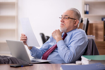 Naklejka premium Old male boss employee working in the office
