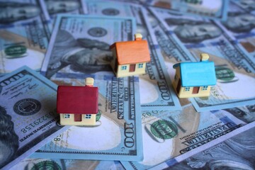 Selective focus image of toy house and money. Real estate, property and housing market concept