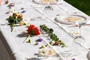 vue sur une table avec une nappe blanche et des fleurs en guise de décoration 