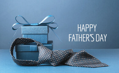 Happy Fathers Day text background banner. Two blue gift boxes with ribbon bow and necktie on dark...