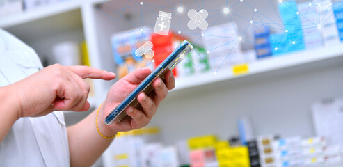 Pharmacist holding mobile phone using for filling prescription in pharmacy drugstore	 - obrazy, fototapety, plakaty