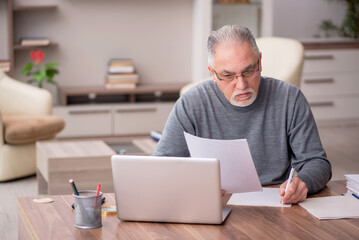 Old male employee working from home during pandemic