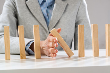 Business woman hand stop domino effect