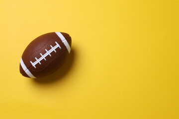 Mini rugby ball isolated on a yellow background. Minimalism Sport concept with copy space.