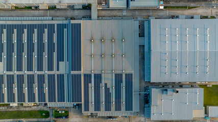 Top view Solar Panels on Warehouse Factory. Solar photo voltaic panels system power or Solar Cell on industrial building roof for producing green ecological electricity. Production of renewable energy