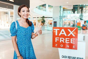 Happy girl customer at the tax free cash refund point in shopping mall or duty free in airport