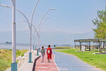 Girl friends walking by picterisque embankment at Besehir lake in Turkey