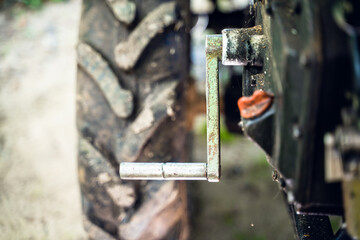 Crooked starter for starting the engine of a walk-behind tractor close-up. Mechanism for manual start of tractor diesel engine