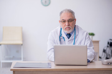 Old male doctor in telemedicine concept