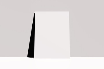 Empty blank white poster leaning on a wall.