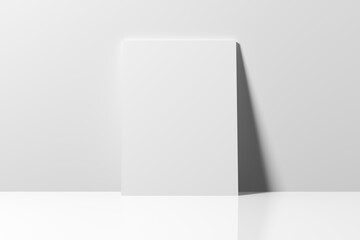 Empty blank white poster leaning on a wall.