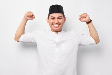 Fototapeta premium Handsome young Asian Muslim man showing arm muscle, confident and proud of power isolated on white background. People religious Islamic lifestyle concept