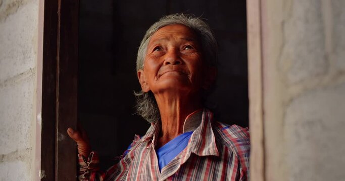 The Asian female farmer woman who is a poor elderly native looked up at the sky as though something had happened. Used in humanity, documentary, lonely person, environment, concepts, or movies.