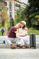 Happy multi-ethnic traveler couple smiling and hugging. Sightseeing in Madrid, Spain.