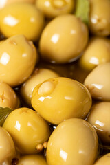 Cheese stuffed olives. Close-up pile of green olives with olive oil and spices