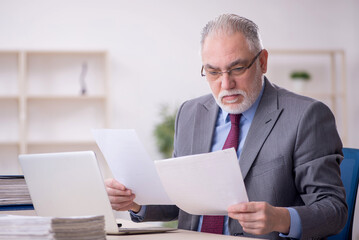 Old male employee working in the office
