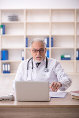 Old male doctor in telemedicine concept