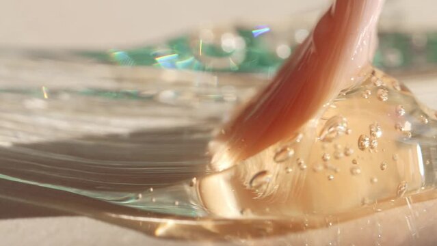 Close-up of a sample of gel cosmetics with bubbles smeared by a cosmetic brush, front view.