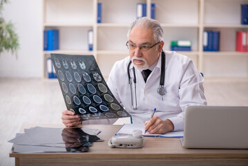 Old male doctor radiologist working in the clinic