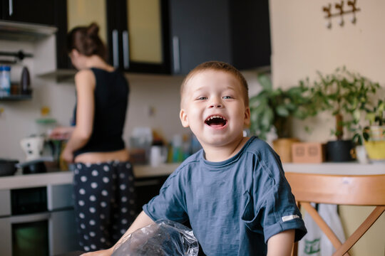 Portrait of happy boy with mother working in background at home