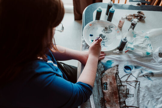 High angle view of teenage girl painting on cloth at home