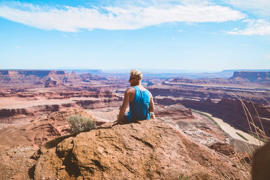Rear view of man looking at rocky mountains against sky