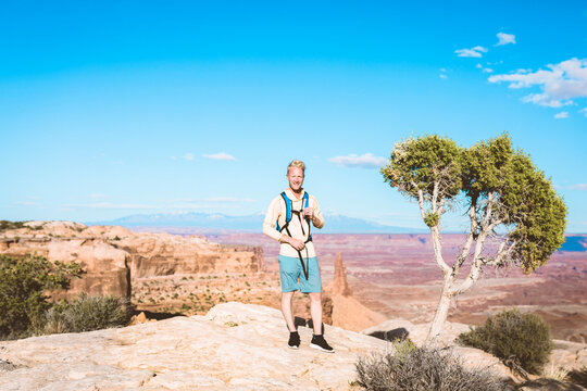 Portrait of male hiker standing on mountain against blue sky