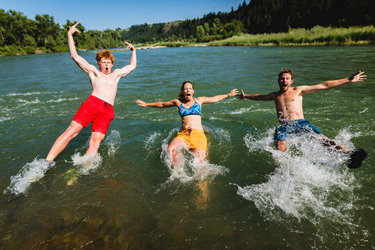 Friends jumping into lake