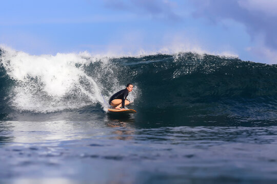 Carefree woman surfing on sea against sky