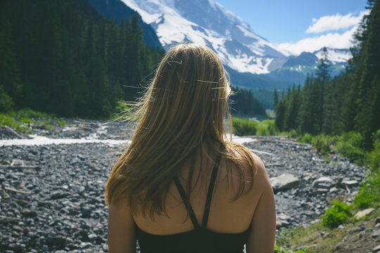Rear view of hiker standing against mountains at Mount Rainer National Park