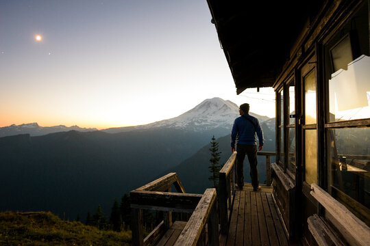 Full length of hiker standing in balcony against mountains and sky at Mount Rainer National Park