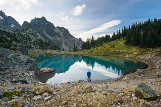 High angle view of hiker standing by lake against mountains at Olympic National Park