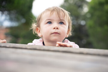 Low angle of a curious and cute little girl outdoors
