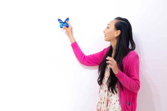 青い蝶を捕まえる女性 
