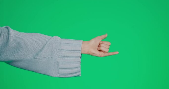 Hand, shaka and a woman on a green screen background in studio to gesture a social media emoji. Surfs up, sign and symbol with the arm of a person alone on chromakey mockup space for hang loose
