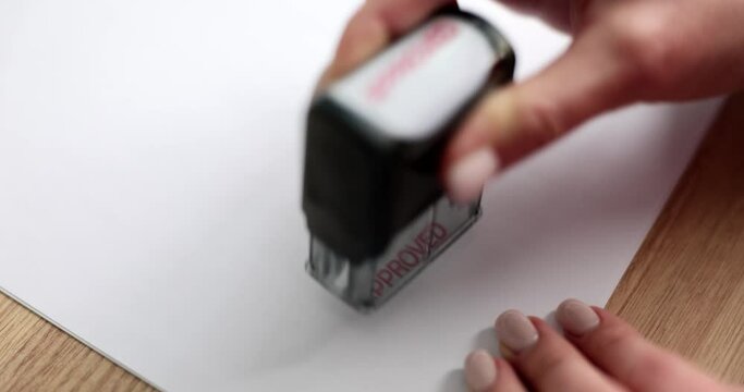 Hand putting stamp approved in red ink on paper closeup 4k movie slow motion