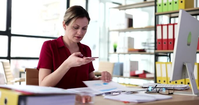 Woman secretary taking pictures of documents on mobile phone in office 4k movie