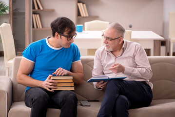 Young male student and his grandfather at home