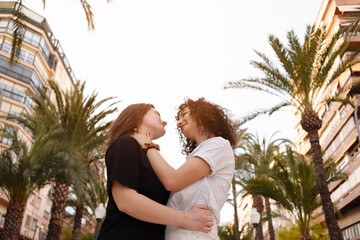 two lesbian girls in love walk through the streets happy on gay pride day