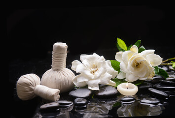 Fototapeta na wymiar Spa still life of zen stones ,candle ,spa ball with drops and gardenia blooming 