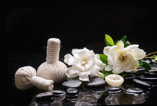 Spa still life of zen stones ,candle ,spa ball with drops and gardenia blooming 
