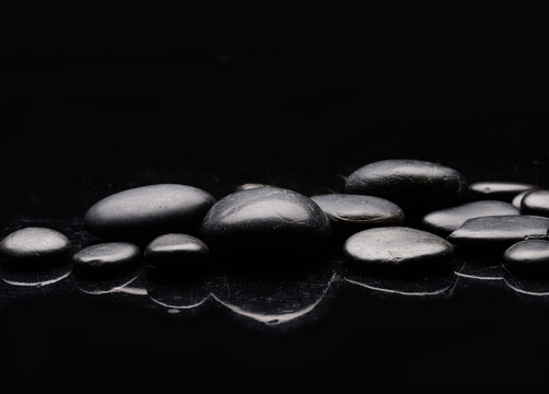 shiny dark spa stones with water drops, reflection 