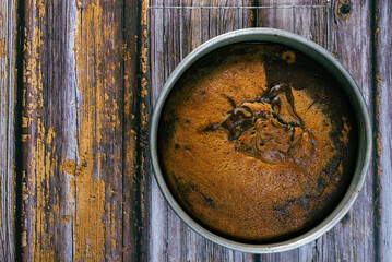 Freshly baked marbled sponge cake cooling on wooden table.