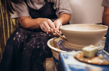 Fototapeta na wymiar Woman hands working on pottery wheel and making a pot.