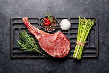 Raw Tomahawk beef steak and spices