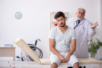 Obraz premium Young male patient visiting old male doctor